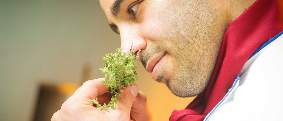 a chef smelling an herb