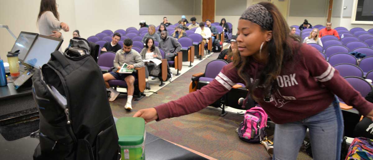 Angelique James, a sophomore majoring in mass communications in the Richard T. Robertson School of Media and Culture, donates pocket change to a fundraising effort led by her statistics professor, Rebecca Durfee