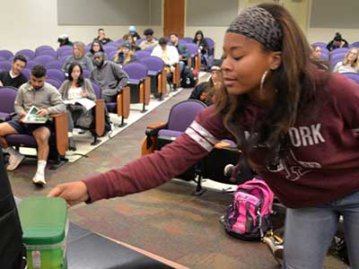 Angelique James, a sophomore majoring in mass communications in the Richard T. Robertson School of Media and Culture, donates pocket change to a fundraising effort led by her statistics professor, Rebecca Durfee